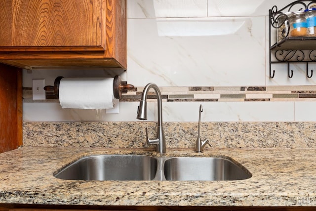 kitchen featuring sink and light stone countertops