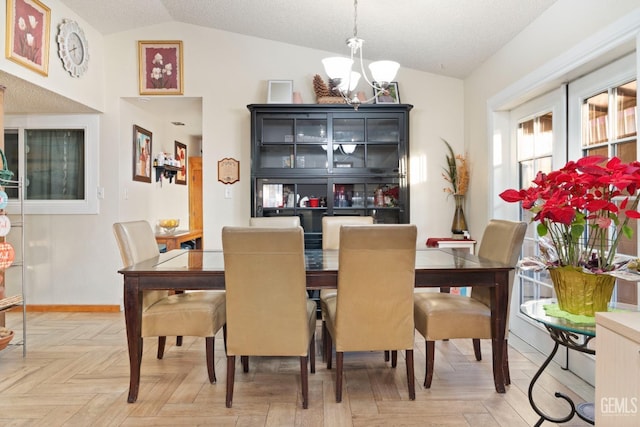 dining space with parquet floors, a textured ceiling, vaulted ceiling, and a chandelier