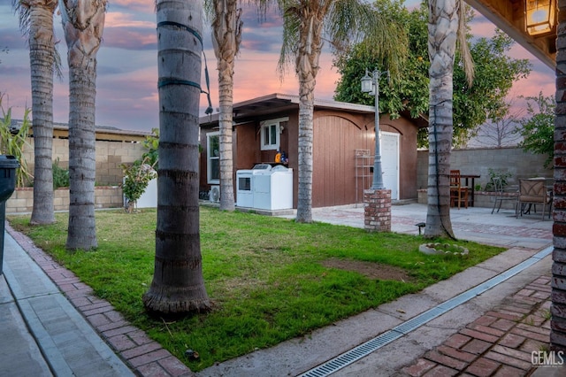 exterior space featuring a yard, washer / dryer, and a patio area