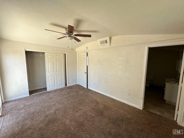 unfurnished bedroom featuring vaulted ceiling, ceiling fan, a textured ceiling, and dark carpet