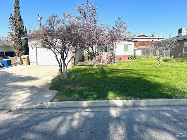 view of front of property featuring a garage, driveway, a front lawn, and central AC