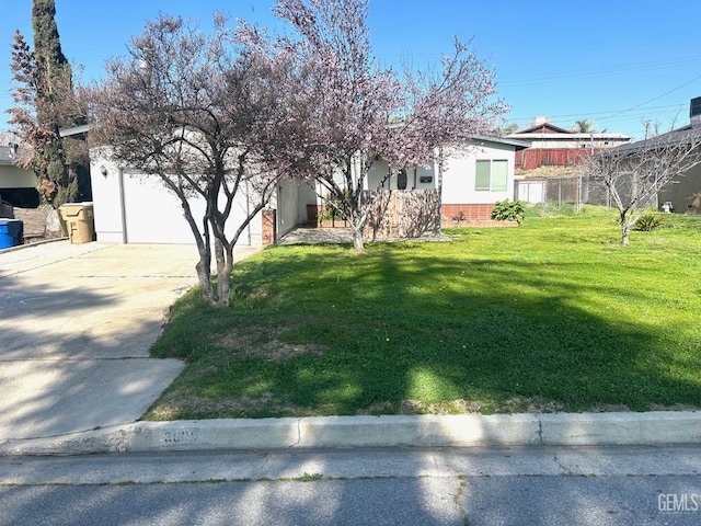 view of front of home featuring a garage, brick siding, concrete driveway, and a front yard