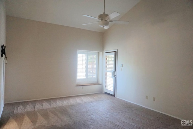 spare room featuring carpet floors, high vaulted ceiling, baseboards, and a ceiling fan