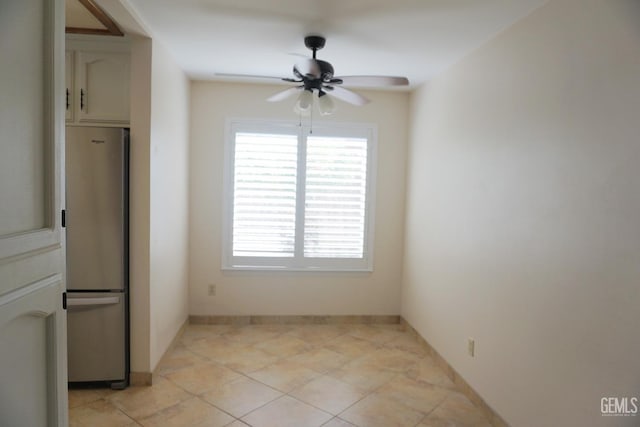 unfurnished dining area featuring a ceiling fan and baseboards