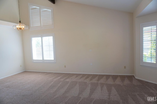 carpeted empty room with baseboards and a notable chandelier