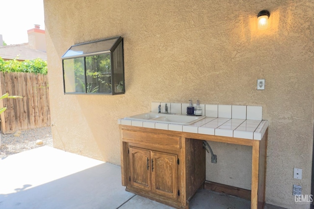 view of patio / terrace featuring fence and a sink