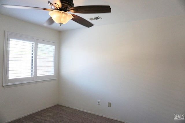 spare room featuring a ceiling fan, visible vents, and carpet flooring