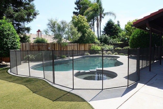 view of swimming pool featuring a patio area, a fenced backyard, and a pool with connected hot tub