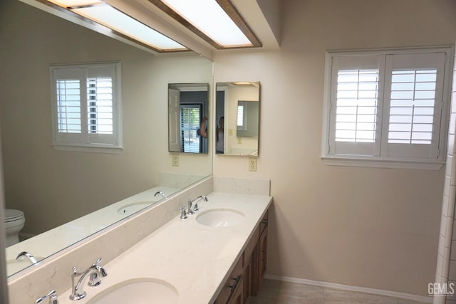 bathroom featuring a sink, baseboards, and double vanity