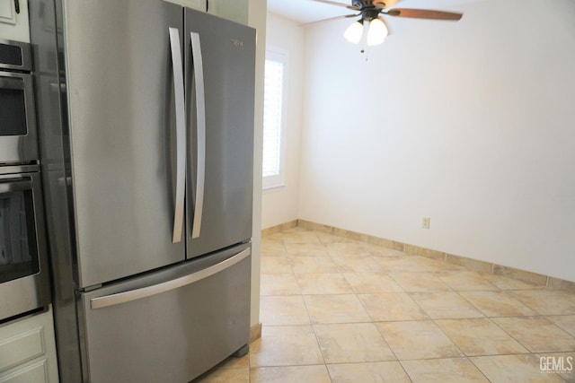 kitchen featuring freestanding refrigerator, ceiling fan, baseboards, and light tile patterned floors