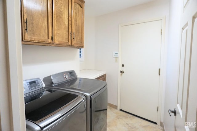 washroom featuring separate washer and dryer and cabinet space