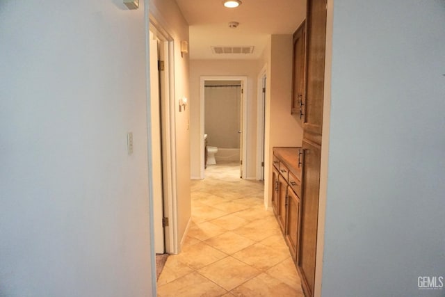 corridor featuring light tile patterned floors, visible vents, and recessed lighting