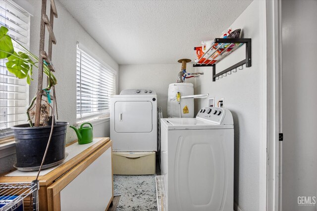 404 Colusa Ave, Chowchilla, CA 93610 - clothes washing area featuring gas water heater, washer and dryer, and a textured ceiling