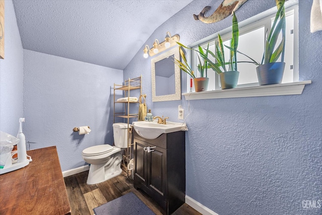 404 Colusa Ave, Chowchilla, CA 93610 - bathroom with a textured wall, wood finished floors, lofted ceiling, toilet, and a textured ceiling