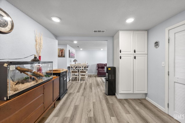 404 Colusa Ave, Chowchilla, CA 93610 - kitchen featuring white cabinets, light wood-style flooring, baseboards, and recessed lighting