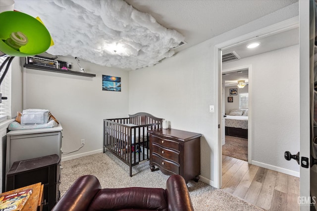 404 Colusa Ave, Chowchilla, CA 93610 - bedroom with baseboards, a nursery area, and wood finished floors