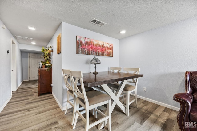 404 Colusa Ave, Chowchilla, CA 93610 - dining area with light wood-style floors, baseboards, and a textured ceiling