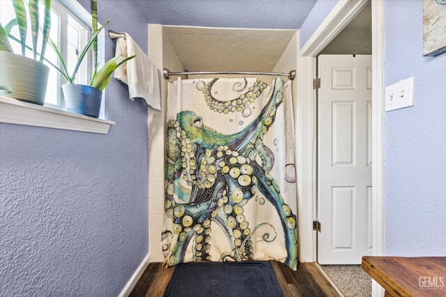 404 Colusa Ave, Chowchilla, CA 93610 - bathroom with a textured wall, curtained shower, wood finished floors, and a textured ceiling