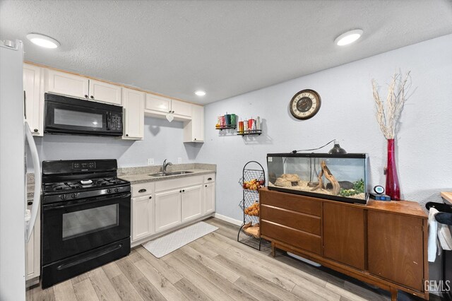 404 Colusa Ave, Chowchilla, CA 93610 - kitchen featuring black appliances, a sink, white cabinets, light wood-type flooring, and baseboards