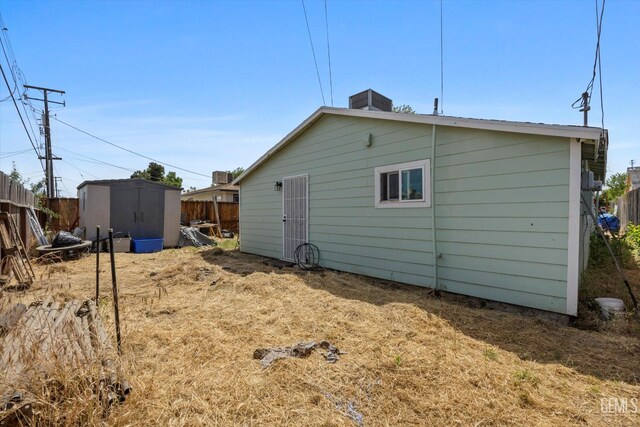 404 Colusa Ave, Chowchilla, CA 93610 - view of side of home with a storage unit, fence, and an outbuilding