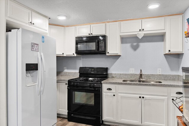 404 Colusa Ave, Chowchilla, CA 93610 - kitchen featuring black appliances, a sink, white cabinetry, light wood-style flooring, and a textured ceiling