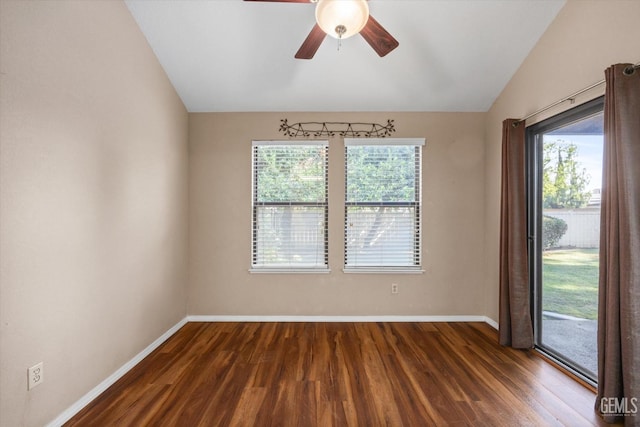 spare room featuring vaulted ceiling, plenty of natural light, and dark wood-type flooring