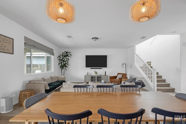 dining area with baseboards, visible vents, and stairs