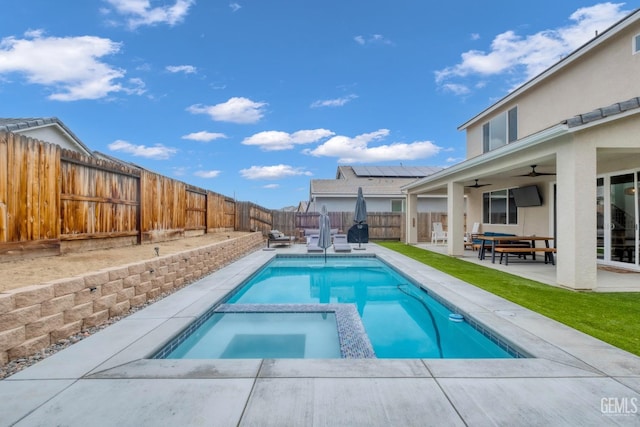 view of swimming pool featuring a patio area, a fenced backyard, a pool with connected hot tub, and ceiling fan