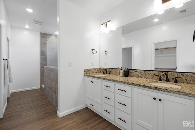 full bathroom with wood finished floors, visible vents, baseboards, and a sink