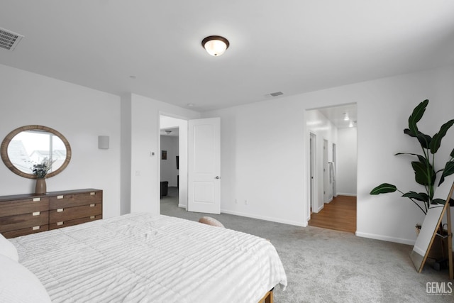 bedroom featuring baseboards, visible vents, and carpet