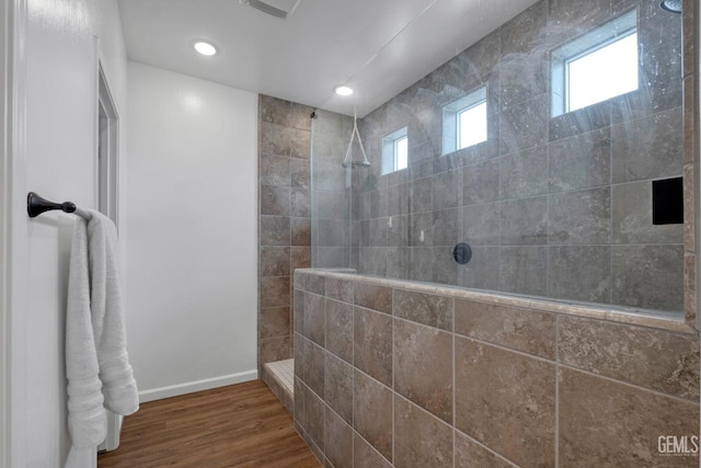 full bathroom with baseboards, wood finished floors, recessed lighting, and a walk in shower