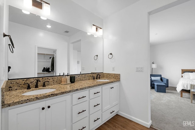 full bath featuring a spacious closet, baseboards, a sink, and double vanity