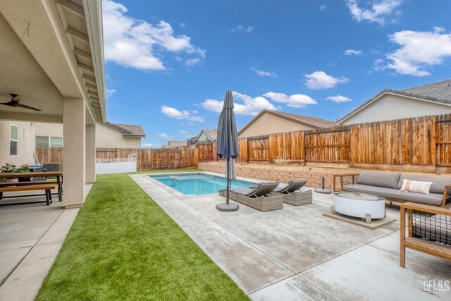 view of swimming pool featuring an outdoor living space, a lawn, a fenced backyard, a patio, and ceiling fan