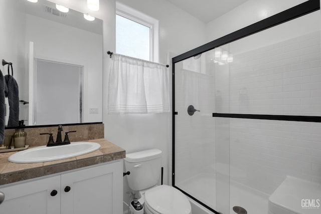 full bathroom with a shower stall, toilet, vanity, and visible vents
