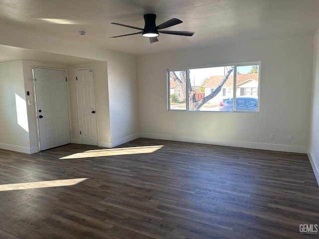 empty room with ceiling fan and dark wood-type flooring