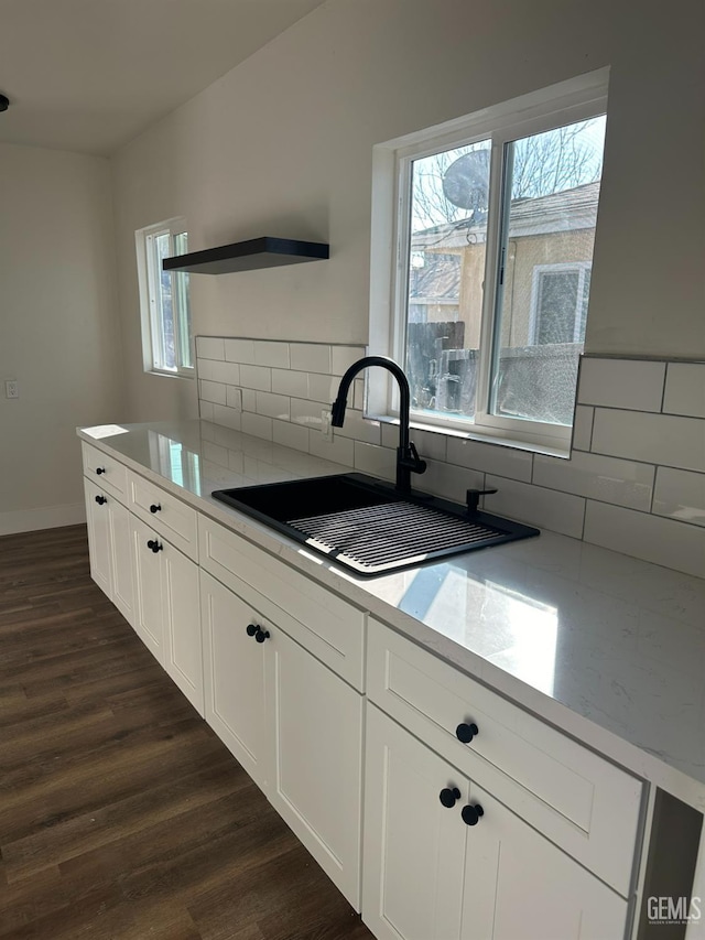 kitchen featuring decorative backsplash, dark hardwood / wood-style floors, white cabinetry, and sink