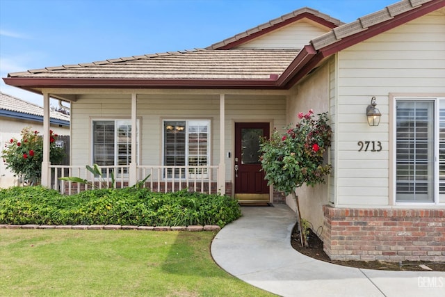 9713 Mona Lisa Ln, Bakersfield, CA 93312 - view of exterior entry with a porch, brick siding, and a yard