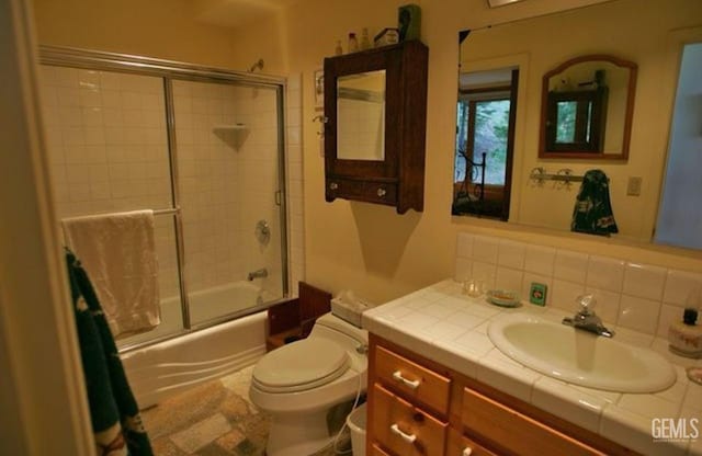 bathroom with enclosed tub / shower combo, tasteful backsplash, toilet, and vanity