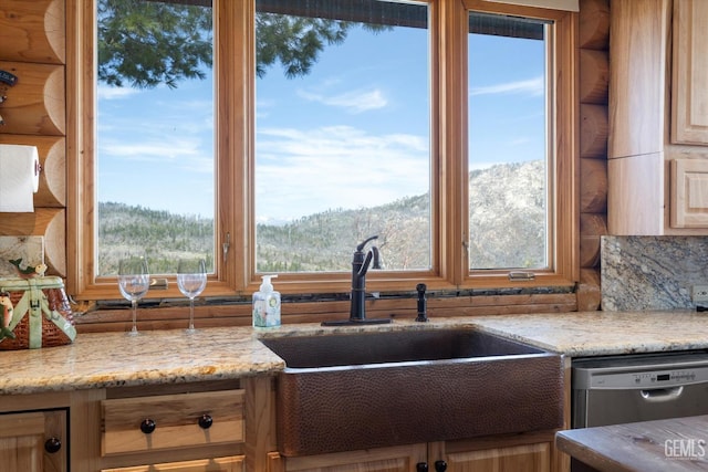 kitchen with plenty of natural light, dishwasher, a sink, and light stone counters