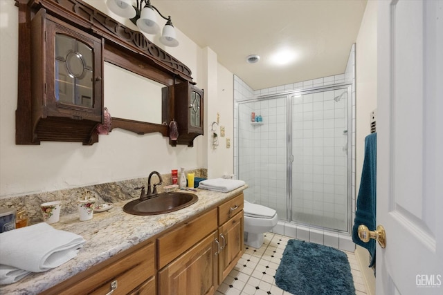 bathroom with toilet, vanity, and a shower stall