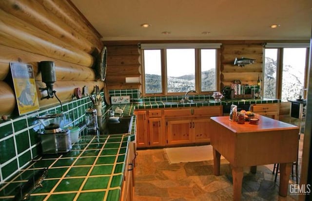 kitchen featuring tile countertops, a sink, and recessed lighting