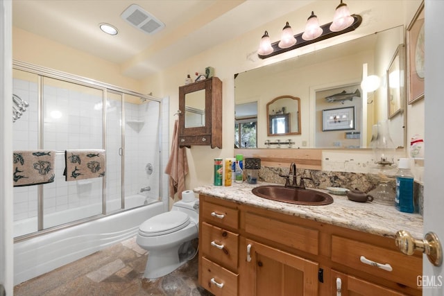 bathroom with shower / bath combination with glass door, vanity, visible vents, and toilet