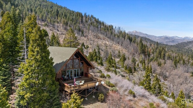 birds eye view of property featuring a forest view and a mountain view