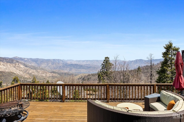 wooden deck with a mountain view and a fire pit