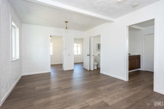 interior space with a textured ceiling, dark hardwood / wood-style flooring, and connected bathroom