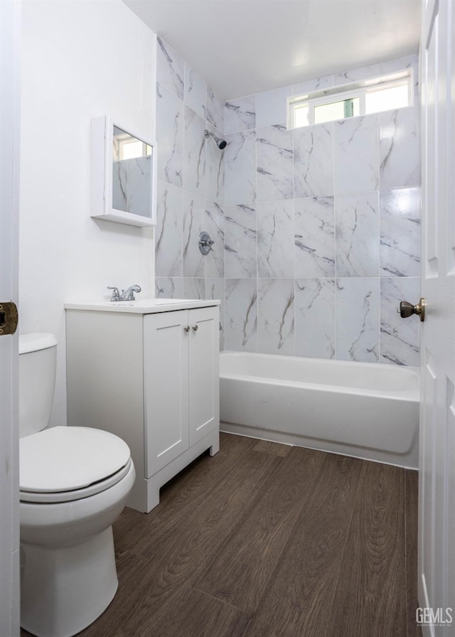 full bathroom featuring toilet, vanity, wood-type flooring, and tiled shower / bath combo