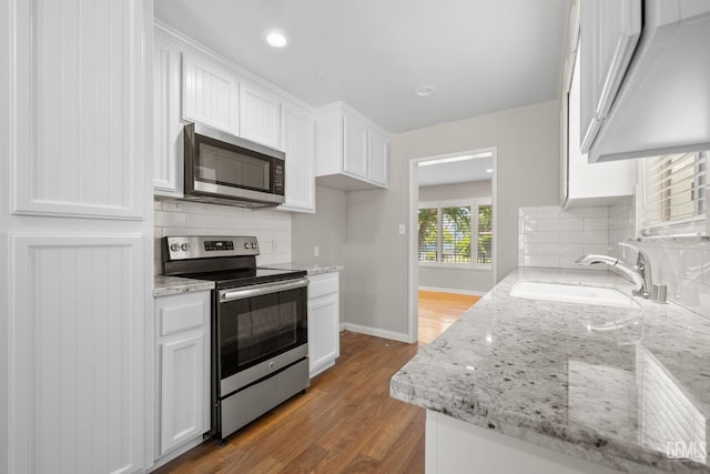 2613 Spruce St, Bakersfield, CA 93301 - kitchen featuring stainless steel appliances, a sink, white cabinetry, decorative backsplash, and recessed lighting