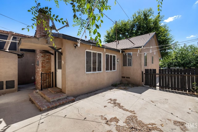 2613 Spruce St, Bakersfield, CA 93301 - rear view of property featuring stucco siding, fence, a patio area, and a chimney