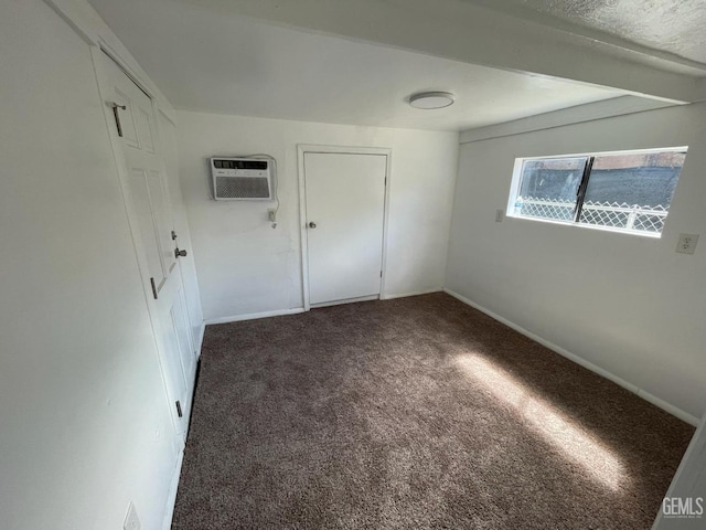 carpeted empty room featuring a wall unit AC