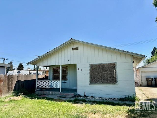 813 E Inyo Ave, Tulare, CA 93274 - view of front of property featuring a front lawn, board and batten siding, covered porch, and fence